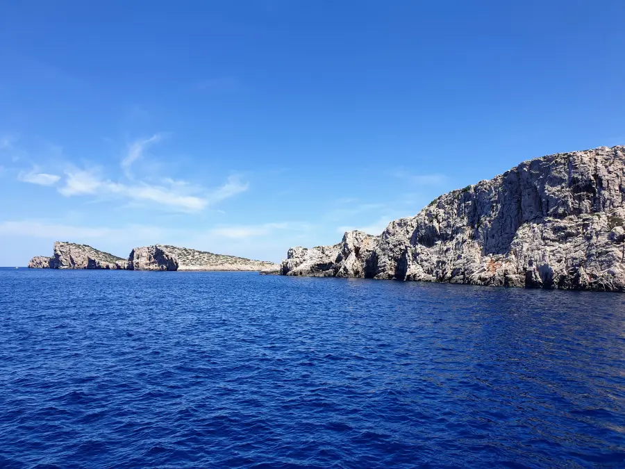 Schroffe Klippen ragen unter klarem Himmel ins tiefblaue Meer und zeigen die dramatische Küste der Insel Murter.