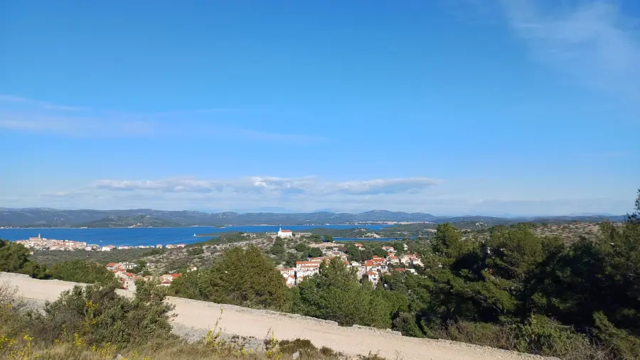 Blick auf eine Stadt auf der Insel Murter mit dem Meer im Hintergrund.